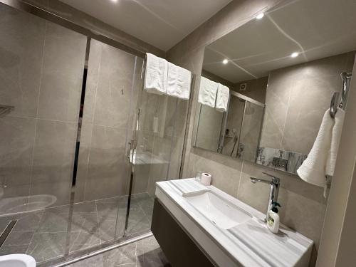 a bathroom with a shower and a sink and a mirror at sea breeze park residences in Mekhrably