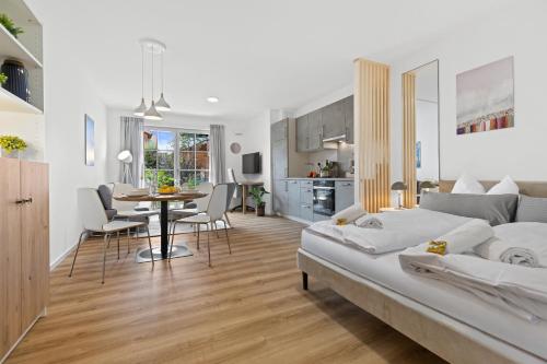 a living room with a bed and a dining room at BALANCED Münsing Ferienwohnungen Nähe Starnberger See in Münsing am Starnberger See