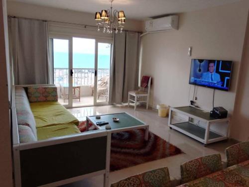 a living room with a couch and a tv at شقه على البحر مباشره فى عمارات الظباط مصطفى كامل سيتي اسكوير in Alexandria