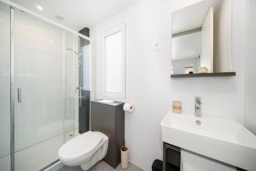 a bathroom with a toilet and a sink and a shower at KAPO Mobile Home in Sitno Donje