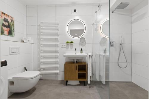 a bathroom with a sink and a toilet and a shower at BALANCED Münsing Ferienwohnungen Nähe Starnberger See in Münsing am Starnberger See