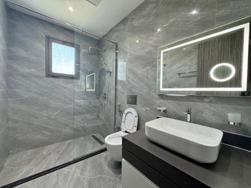 a bathroom with a sink and a toilet and a shower at Breathtaking Sea Views& Balcony Luxurious Stay in Manama