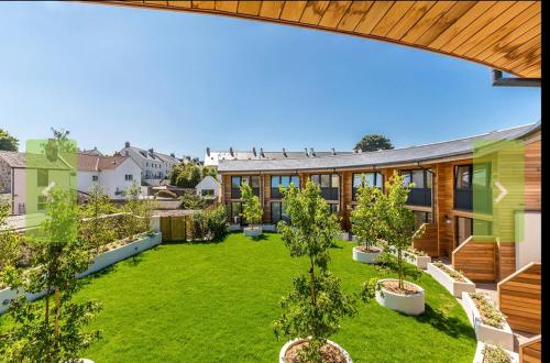 an open courtyard with trees and a building at Escape to Infinity! in Guernsey