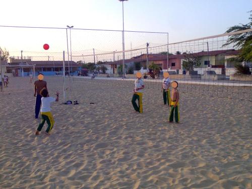 a group of children playing with a volley ball on the beach at Casa Grande in Galinhos