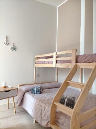 a bedroom with a bunk bed and a desk at Da BeA in Villasimius