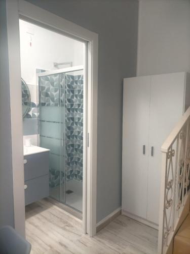 a bathroom with a glass shower and a sink at Da BeA in Villasimius