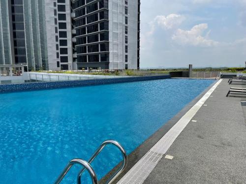 a large blue swimming pool with two tall buildings at D'pristine 4 bedroom condo 1725 opposite Legoland and Medini mall in Iskandar Puteri