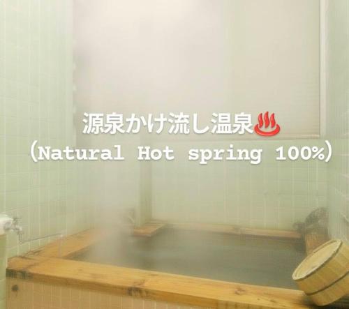 a bathroom with a bath tub in a room at Kaido Yuzawa Onsen Hostel in Yuzawa