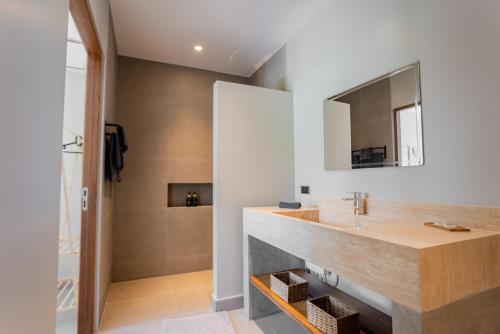 un baño con lavabo y espejo en Villa MAÏA, en Koh Samui 