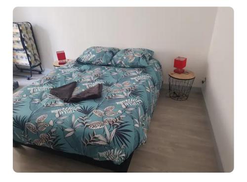a bedroom with a bed with a blue comforter at Petite maison cosy wifi avec terrasse in Montigny-le-Gannelon