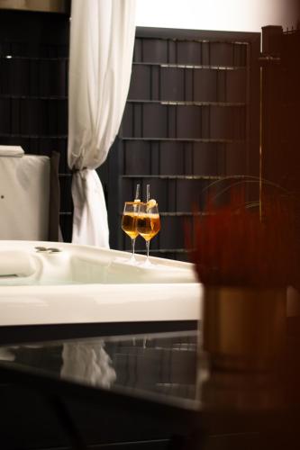 two glasses of wine sitting on a bath tub at Spa Cottage Serenity Chalet in Rittersdorf