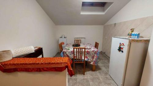 a small kitchen with a table and a refrigerator at ApartRelax in SantʼEufemia a Maiella