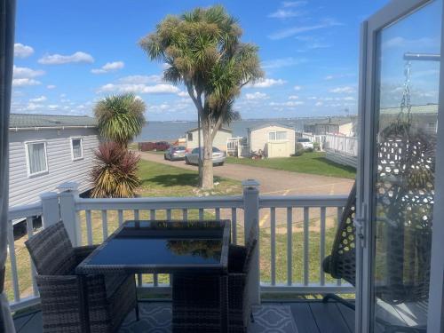 AllhallowsにあるHaven caravan Kent coast sleeps 6 with WiFiの海の景色を望むバルコニー(テーブル付)