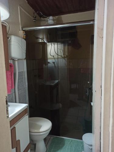 a bathroom with a toilet and a glass shower door at apta para cargar auto eléctrico casa verde 2 pisos in Rivera