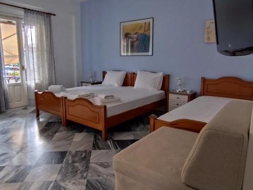 a bedroom with two beds and a couch at Grivas Apartments in Sivota