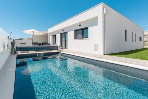 a swimming pool in front of a house at Villa Laura with private swimming pool in Lourinhã
