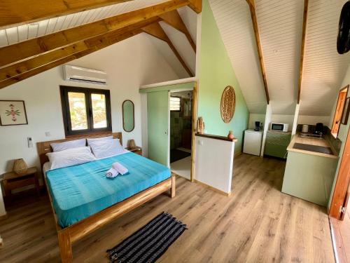 a bedroom with a bed with a blue comforter at Caribbean Shelter in Bouillante