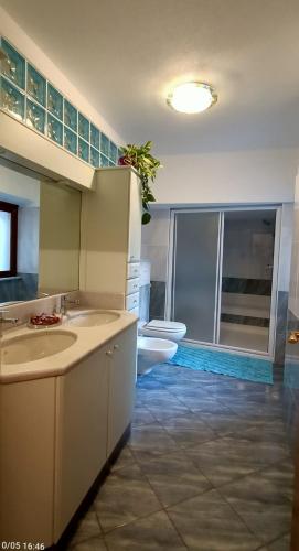 a bathroom with two sinks and a toilet at Residenza dentro le mura - 5 min walk to Bernina Express in Tirano