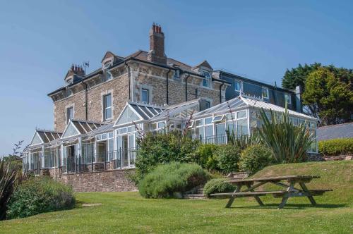 a large building with a bench in front of it at Sure Hotel Collection by Best Western Porth Veor Manor Hotel in Newquay