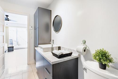 a white bathroom with a sink and a mirror at Logement neuf, spacieux in Longueuil