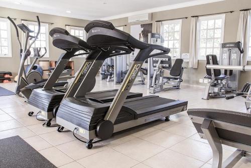 a gym with treadmills and machines in a room at Vila Real Hotel in Jaú