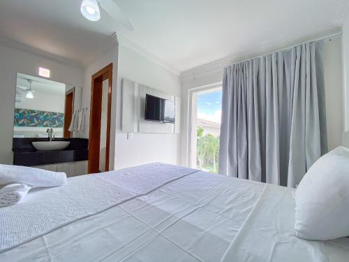 Katil atau katil-katil dalam bilik di Casa toda climatizada com 2 suítes, gourmet privativo e internet 300MBPS no Residencial Monte das Oliveiras em Arraial D'Ajuda , condomínio com piscinas, sauna e portaria 24hrs.