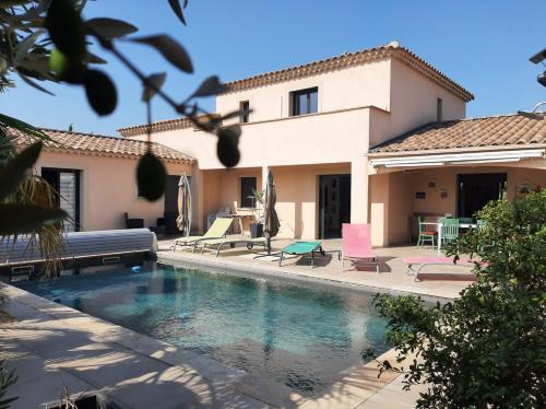 eine Villa mit Swimmingpool vor einem Haus in der Unterkunft Les Figues in Caromb