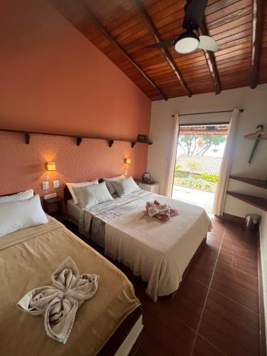 a bedroom with two beds with towels on them at Fauna in Praia do Bananal
