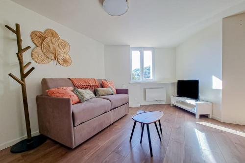 ein Wohnzimmer mit Sofa und Tisch in der Unterkunft Cozy 1BR in the heart of the old village of Villeneuve-Loubet - BENAKEY in Villeneuve-Loubet