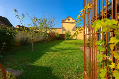 ein Tor in einem Hof mit einem Gebäude in der Unterkunft Le Relais d'Ezy - 3 chambres in Ézy-sur-Eure