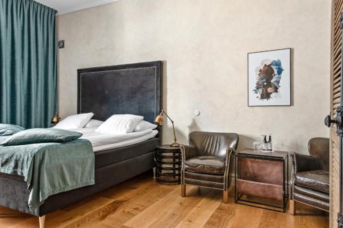 a bedroom with a bed and a chair at Donners Hotell in Visby