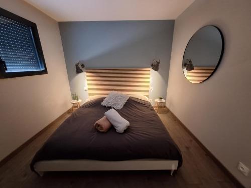a baby laying on a bed in a bedroom at Parenthèse contemporaine - Élégance et nature in Parigné-lʼÉvêque