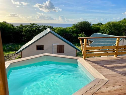 a swimming pool on a deck next to a house at Caribbean Shelter in Bouillante