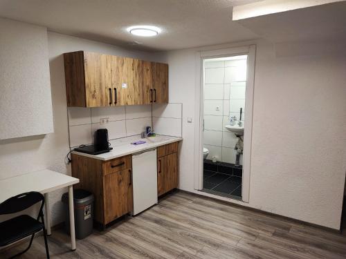 a small kitchen with wooden cabinets and a sink at Heidenheimer Zimmer in Heidenheim