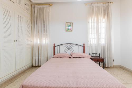 a bedroom with a large bed with pink sheets at Zenitude Villa Moroccan style and quiet neighborhood in Agadir
