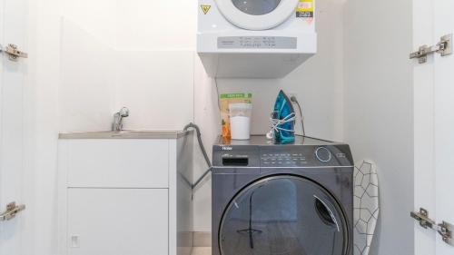 シドニーにあるLeafy Retreat Spacious 2B Penthouse 1 Parkingの小さな部屋(シンク付)の洗濯機