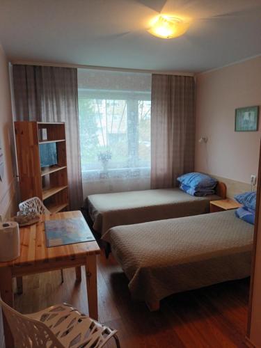a hotel room with two beds and a table at Mahtra Hostel in Tallinn
