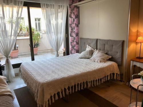 a bedroom with a bed and a large window at Gray d' Albion Apartment in Cannes