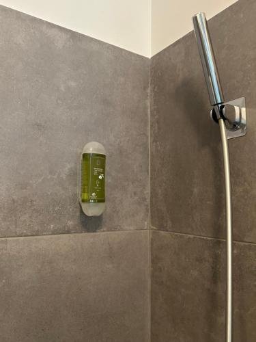 a bathroom with a green soap dispenser on a wall at Burnay Porto Suites in Porto