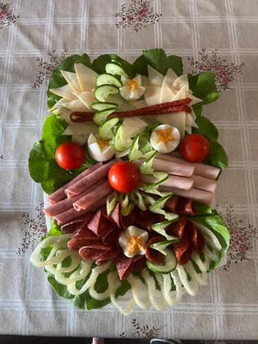 Un plato de comida con carne y verduras encima. en Mythos Private Resort, en Pécs