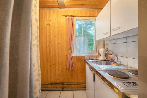 a kitchen with a wooden wall and a window at Bungalow 30 - Kimbucht in Reichendorf