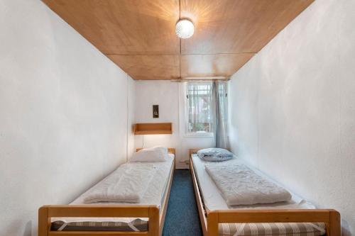 a small room with two beds and a window at Bungalow 32 - Kimbucht in Reichendorf