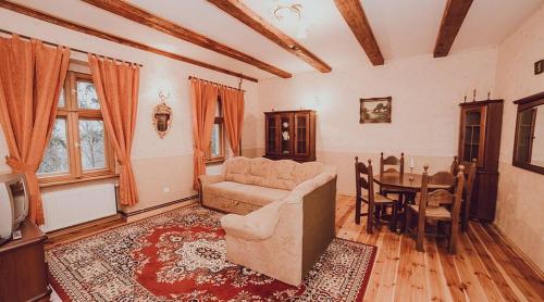 a living room with a couch and a table at Palac Kursko Agroturystik in Kursko