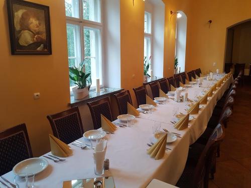 a long dining room with white tables and chairs at Palac Kursko Agroturystik in Kursko