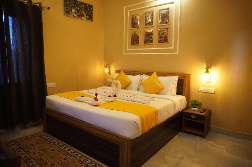 a bedroom with a large bed with yellow sheets at Bagh mahal by jungle vibes in Sawāi Mādhopur