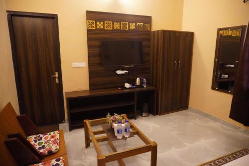 a living room with a tv and a table at Bagh mahal by jungle vibes in Sawāi Mādhopur