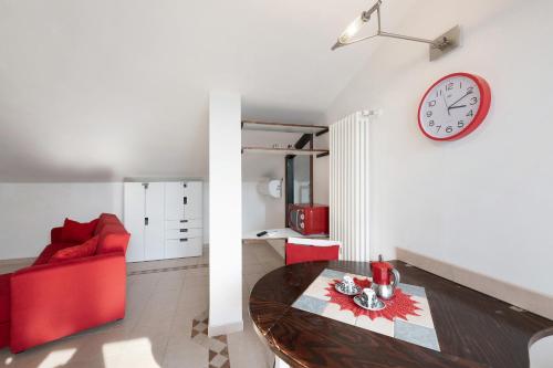 a living room with a table and a clock on the wall at Wohnung Am Gardasee Mit Seeblick No in Bardolino
