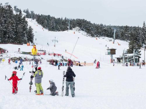 a group of people on a snow covered ski slope at Les lupins in Bolquere Pyrenees 2000