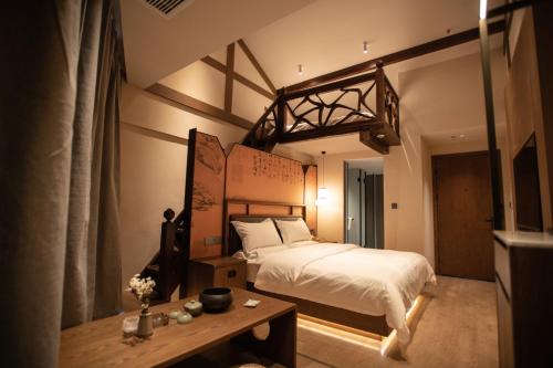 a bedroom with a large bed and a table at Liu Ruju Song's Courtyard in Lijiang