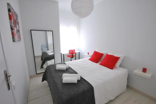 バルセロナにあるArgentona SDBのベッドルーム1室(赤い枕と鏡付きのベッド1台付)